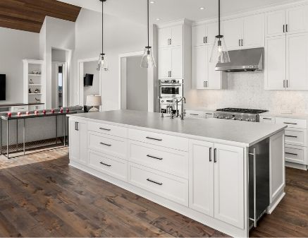 A modern kitchen that looks newly remodeled. The kitchen features white cabinets, whiter marble countertops, and vintage class bulb lighting.