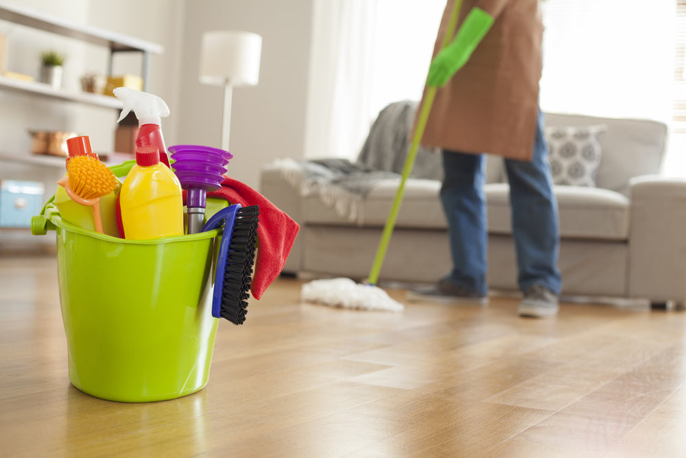 Man holding mop and plastic bucket to clean wood floors