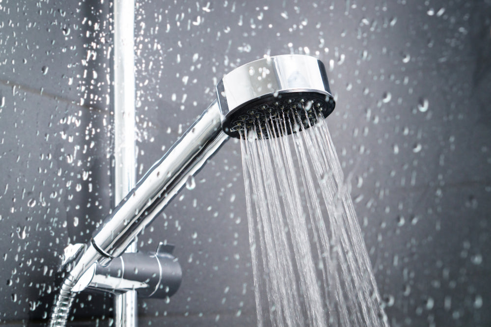 Water running from shower head and faucet in modern bathroom.