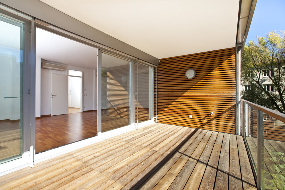 Wall Paneling - architectural contemporary - sunlit balcony with wooden floor and wall of an apartment building in green area.