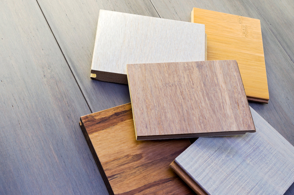 five flooring sample pieces tongue and groove design on top of wide plank bamboo floor